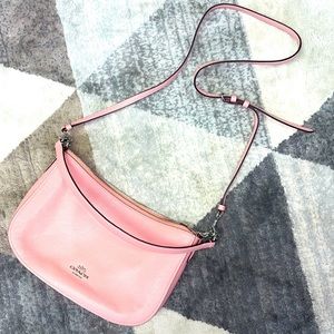 Coach pink handbag with crossbody strap.